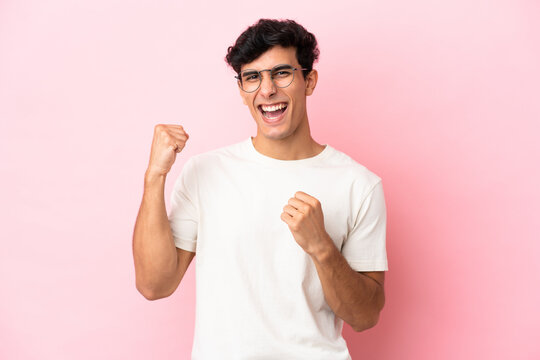 Young Argentinian man isolated on pink background celebrating a victory