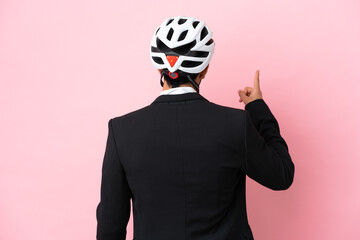 Argentinian businessman with bike helmen isoleted on pink background