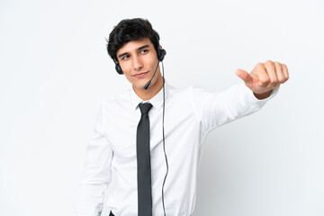Telemarketer man working with a headset isolated on white background giving a thumbs up gesture