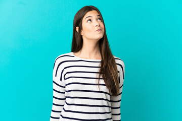 Fototapeta premium Teenager Brazilian girl over isolated blue background and looking up