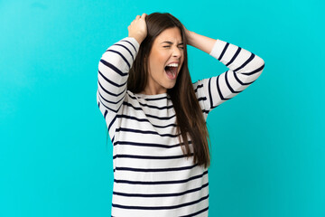 Teenager Brazilian girl over isolated blue background stressed overwhelmed