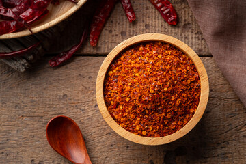 Dried red hot chilli powder in wooden bowl.Hot and spicy asian Condiments.Top view
