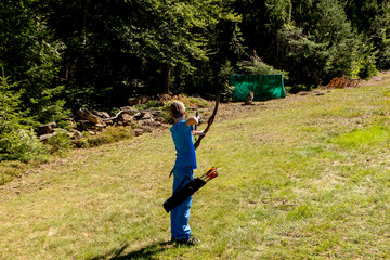 boy with blue shirt bow and arches shooting 