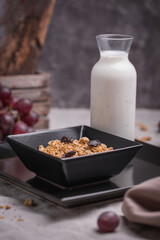 healthy breakfast oatmeal with granola and raisins in a bowl and yogurt with chia