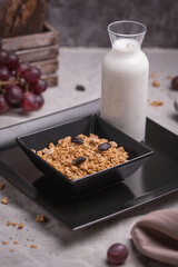 healthy breakfast oatmeal with granola and raisins in a bowl and yogurt with chia