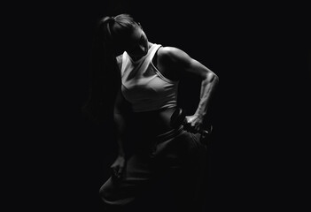 Athletic fitness woman posing in the studio on a dark background. Photo of an attractive woman in...