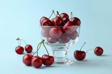 Fresh ripe cherries on light blue background