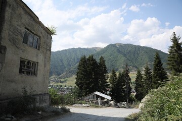 Fototapeta na wymiar Picturesque view of beautiful mountains, trees and old building
