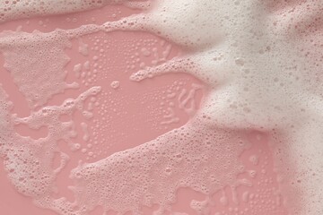 Fototapeta premium White washing foam on pale pink background, top view