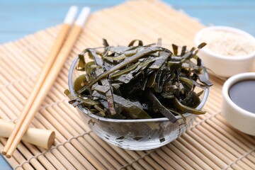 Fresh laminaria (kelp) seaweed served on light blue wooden table, closeup