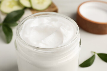 Fototapeta na wymiar Glass jar of face cream on white table, closeup
