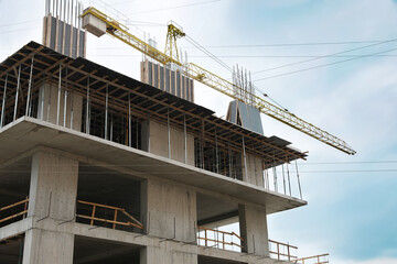 Construction site with tower crane near unfinished building