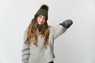 Young caucasian woman with winter hat isolated on white background giving a thumbs up gesture