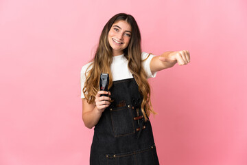 Young hairdresser woman isolated on pink background giving a thumbs up gesture