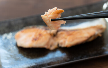 北海道産の焼き鮭を箸で持ち上げている