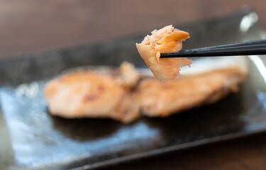 北海道産の焼き鮭を箸で持ち上げている