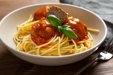 Close up of Spaghetti with meatball and red sauce in bowl food on wooden table