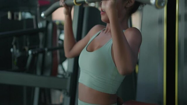 Young black female doing exercises fitness training chest muscles on machine in gym. Fitness athlete beautiful woman wearing sportswear workout with weight equipment. Healthy lifestyle concept.
