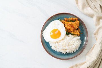 stir-fried fried fish with basil and fried egg topped on rice