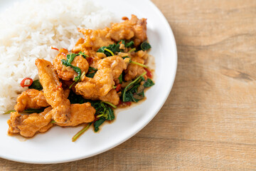 stir-fried fried fish with basil and chili in thai style topped on rice