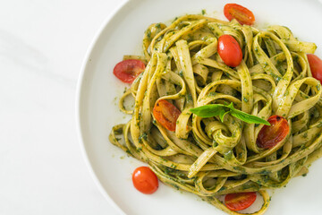 fettuccine spaghetti pasta with pesto sauce and tomatoes