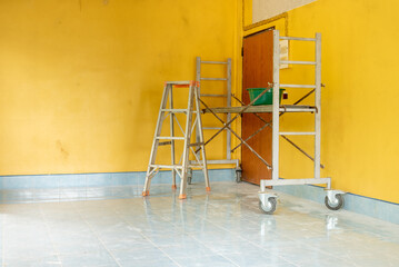 Steel stairs and tools for home renovation in the yellow room.