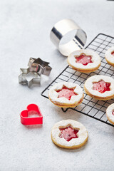 Classic Linzer Christmas Cookies with raspberry or strawberry jam on light background.