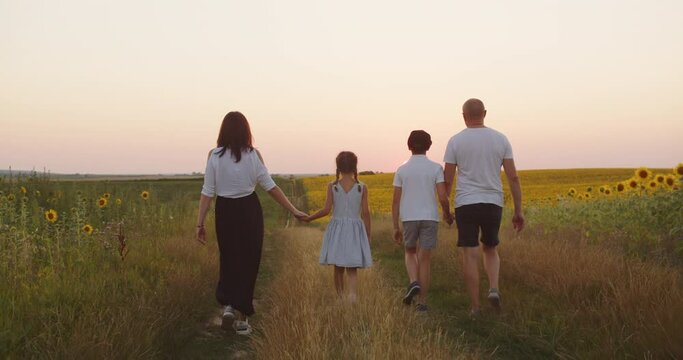 A family with children walks in nature on a sunny summer day