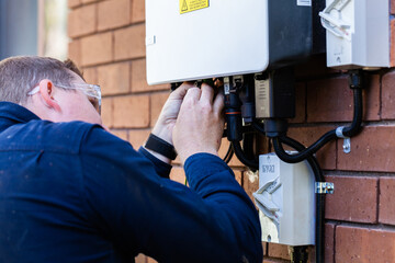 Electrician plugging in plugs to activate solar power