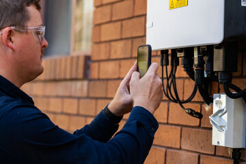 Tradesman scanning qr code on solar power controller box
