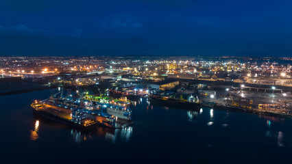 Fototapeta na wymiar aerial view shipyard dry dock maintenance and repair container ship transport and oil ships in sea, business and industry service at night over lighting cityscape blue sky background