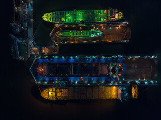 aerial view shipyard dry dock maintenance and repair container ship transport and oil ships in sea, business and industry service at night over lighting