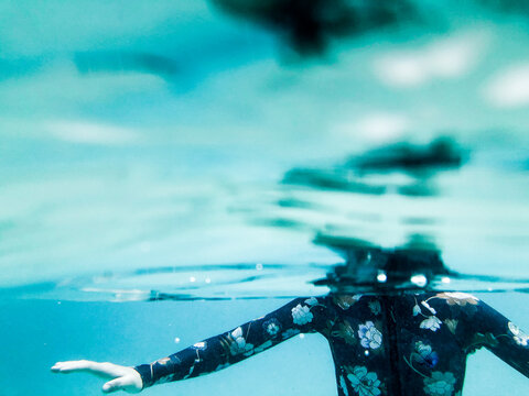 Female underwater in ocean wearing full piece swimsuit