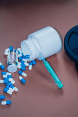 dumbbells, syringe with needle and vial with steroids. illegal doping in sport concept