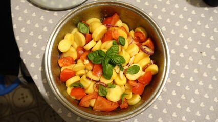 A bowl of fresh tomato salad, potatoes, Tropea onions and basil.