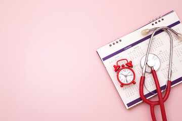 alarm clock timer and stethoscope placed on calendar, plan to annual medical health checkup concept - 538599762