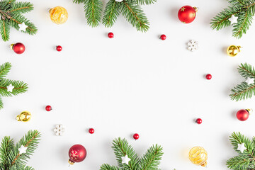 Christmas composition. Frame made of fir tree, festive decorations, red berries on white background. Flat lay