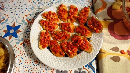 A plate of bruschette with fresh tomatoes and basil.