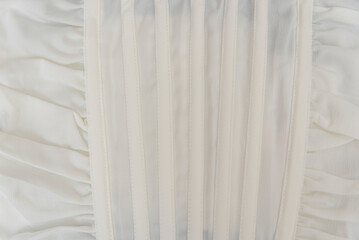 Texture of white cotton fabric. Part of satin clothes corset. Natural textile cream milky color.