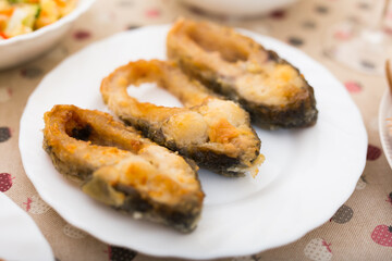 three pieces of fried carp on a white plate