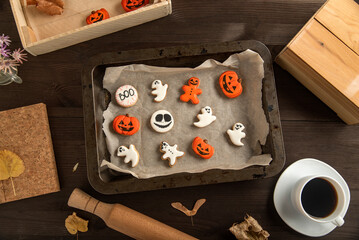 Ginger cookies for Halloween lie in a wooden form. Cup of coffee and gingerbreads on table. Top view
