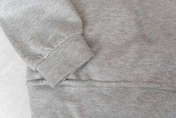 Fototapeta na wymiar Cuff and part gray sweatshirt on white background. Warm casual unisex clothing. Close up