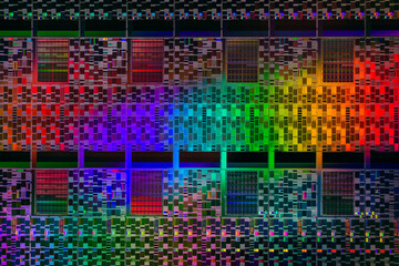 Silicon semiconductor wafer in rainbow light, macro shot showing components of process equipment processor chips