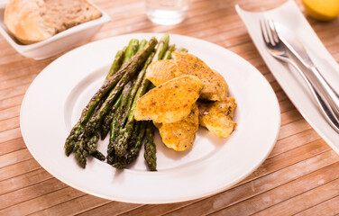 cooked dish. Chicken nuggets with green asparagus on plate