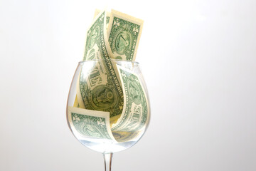 dollar money in an empty wine glass. Online business sale. Financial success in the trading...