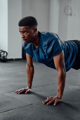 Obraz premium Athletic young black man doing push-ups at the gym