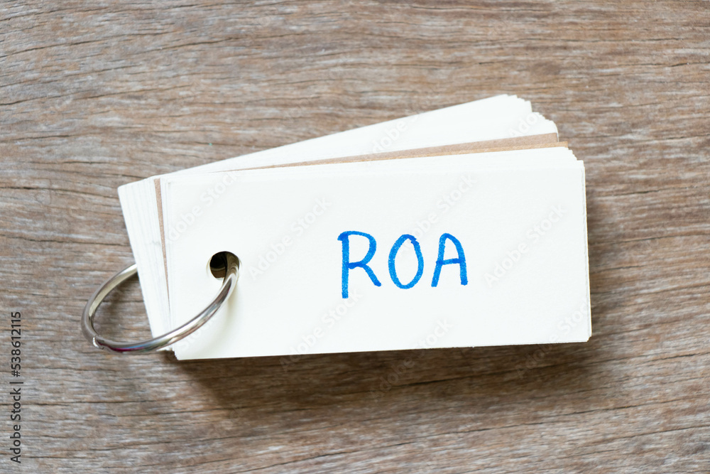 Wall mural Flash card with handwriting in word ROA (Abbreviation of Return on assets) on wood background