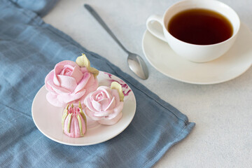 tea set in a composition with marshmallow flowers. Coffee mug on a saucer. on a light gray background