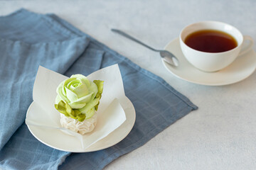 tea set in a composition with marshmallow flowers. Coffee mug on a saucer. on a light gray background