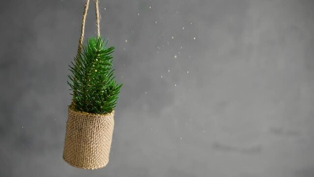 New Year's Eve, Christmas composition. golden sequins fall on spruce branches on a gray background with copy space